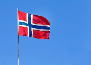 The Norwegian flag flies in the wind.