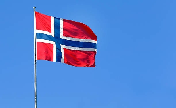 The Norwegian flag flies in the wind.