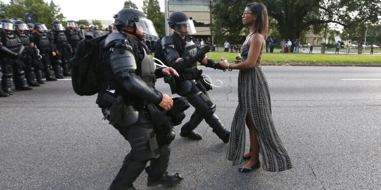 Lone activist Ieshia Evans stands her ground while offering her hands for arrest as riot police charge towards her during a protest against police brutality outside the Baton Rouge Police Department in Louisiana, U.S. on July 9, 2016. Evans, a 27-year-old Pennsylvania nurse and mother to a young boy, traveled to Baton Rouge to protest the shooting of Alton Sterling, a 37-year-black man and father of five, who was shot at close range while being held down by two white police officers. The shooting, captured on cell phone videos, aggravated the unrest that has coursed through the United States for two years over the use of excessive force by police, especially against black men. REUTERS/Jonathan Bachman