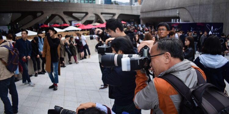 group of photographers holding DSLR cameras in event during daytime