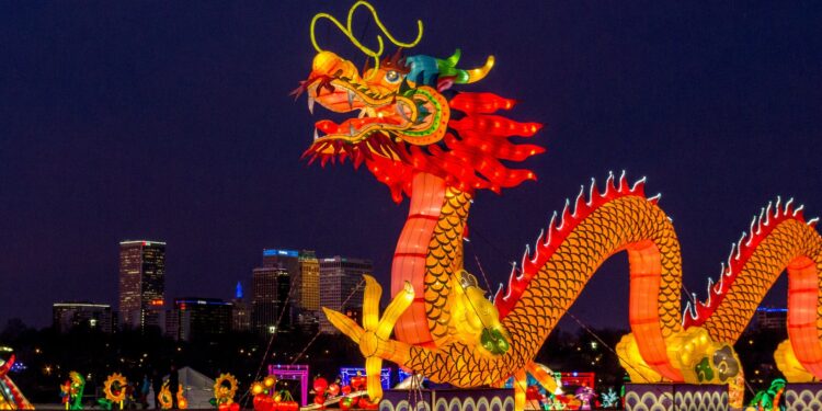 people walking on street with dragon statue during night time