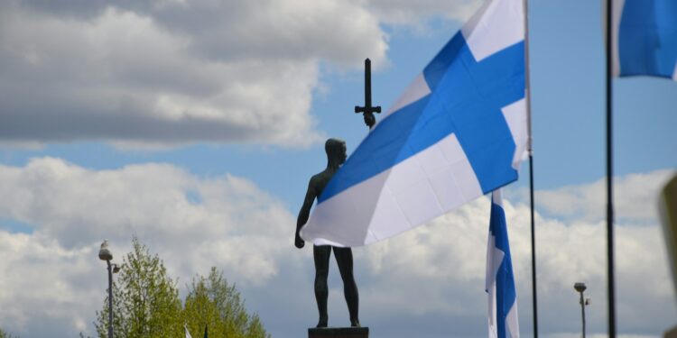 a statue of a person holding a cross and a flag