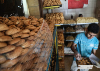 Worker packing cookies in preparation for the Celebration of the Eid al-Fitr holiday which marks the end of the Muslim's holy fasting month of Ramadan ahead of Eid al-Fitr 1443 H at a bakery in downtown Cairo ,Egypt April 28, 2022. (Photo by Ayman Aref/NurPhoto) (Photo by Ayman Aref / NurPhoto / NurPhoto via AFP)