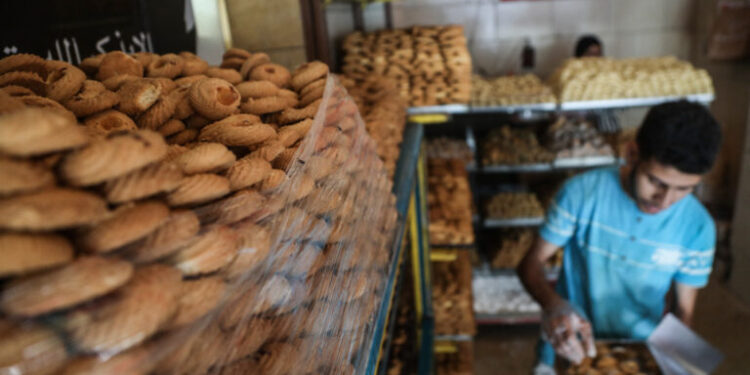 Worker packing cookies in preparation for the Celebration of the Eid al-Fitr holiday which marks the end of the Muslim's holy fasting month of Ramadan ahead of Eid al-Fitr 1443 H at a bakery in downtown Cairo ,Egypt April 28, 2022. (Photo by Ayman Aref/NurPhoto) (Photo by Ayman Aref / NurPhoto / NurPhoto via AFP)