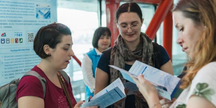 (240801) -- BEIJING, Aug. 1, 2024 (Xinhua) -- International visitors read manuals for Beijing Pass at Beijing Capital International Airport in Beijing, capital of China, July 31, 2024. TO GO WITH "Beijing issues prepaid cards for international visitors" (Xinhua)